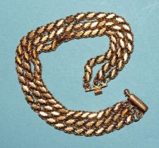 A bracelet of three fancy-link chains, unmarked, tests as approximately 18ct gold, 27.7g.