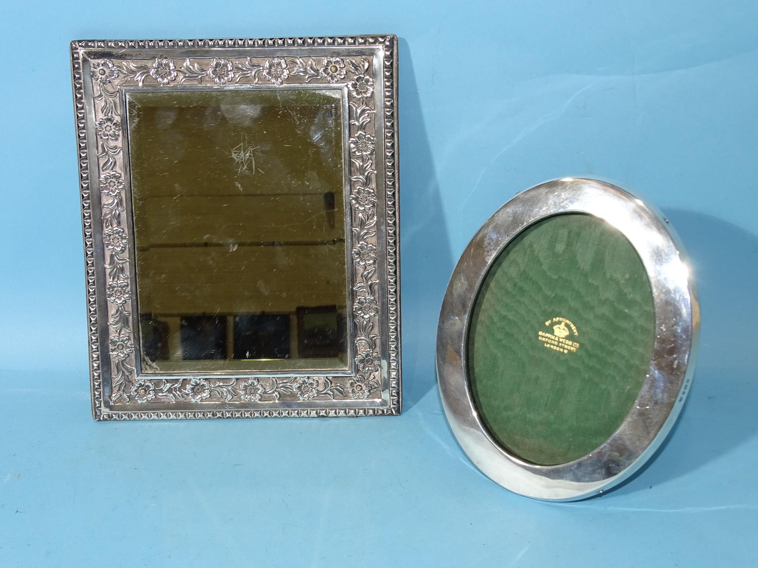 A late Victorian silver framed rectangular wall mirror, the border with embossed floral