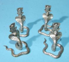 A set of four white metal place setting holders in the form of a cobra with a frog on its head,