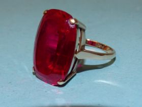 A 9ct gold dress ring set large synthetic ruby, 21 x 15mm, size P, 8.3g.