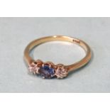 A sapphire and diamond three-stone ring claw-set a round-cut sapphire between two brilliant-cut