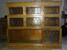 A Minty oak bookcase, having seven leaded glazed small doors, 134cm wide, 117cm high, (some damage