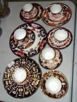 A collection of Crown Derby tea ware decorated in various Imari-style patterns, twenty-two