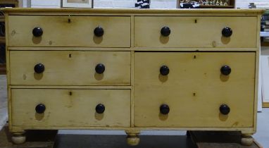 A low pine bank of five large drawers, on turned feet, 160cm wide, 86cm high.