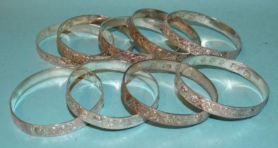Nine silver bangles with an embossed Celtic snake design, each hallmarked for Gordon H Walker,
