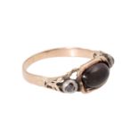 Ring mit ovalem Granatcabochon flankiert von Diamantrosen