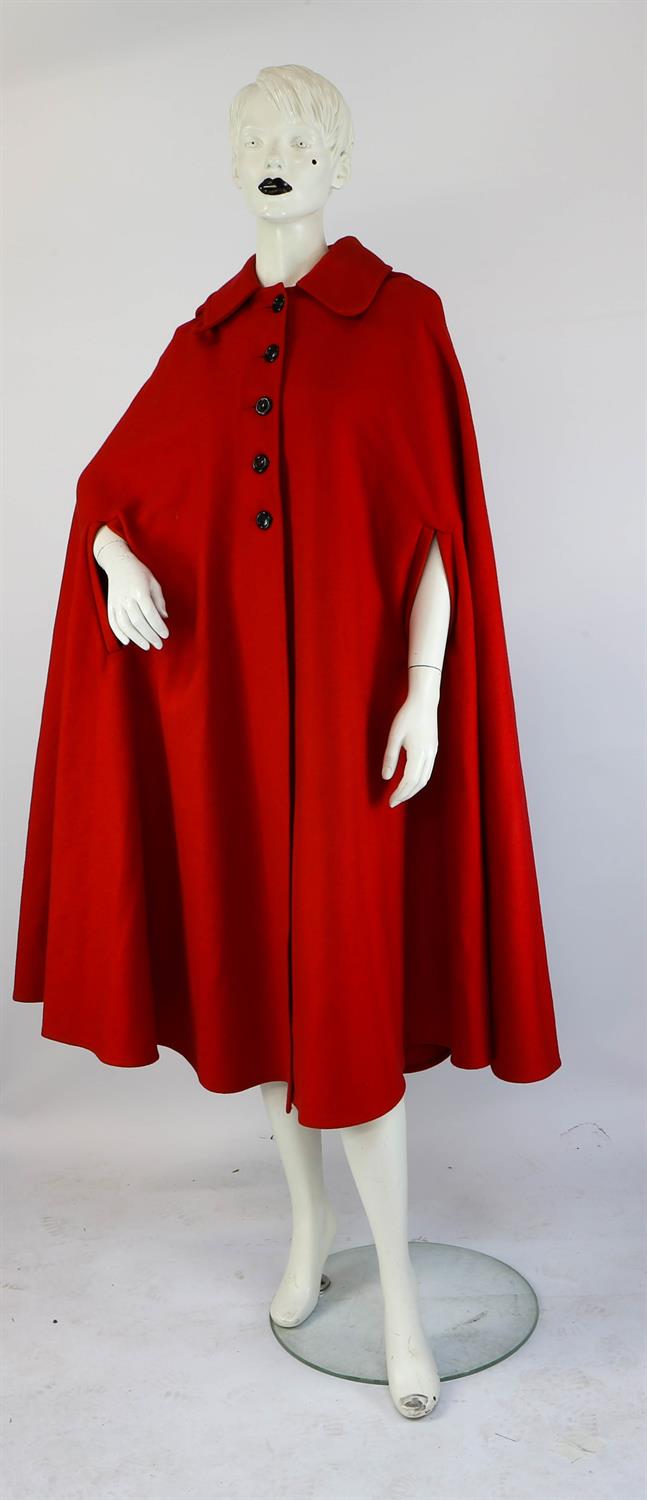 A 1970s original heavy cherry red wool long-length cape with hood, black buttons and arm slits.