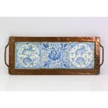 Copper tray inset with three blue and white tiles and an oak framed aneroid barometer