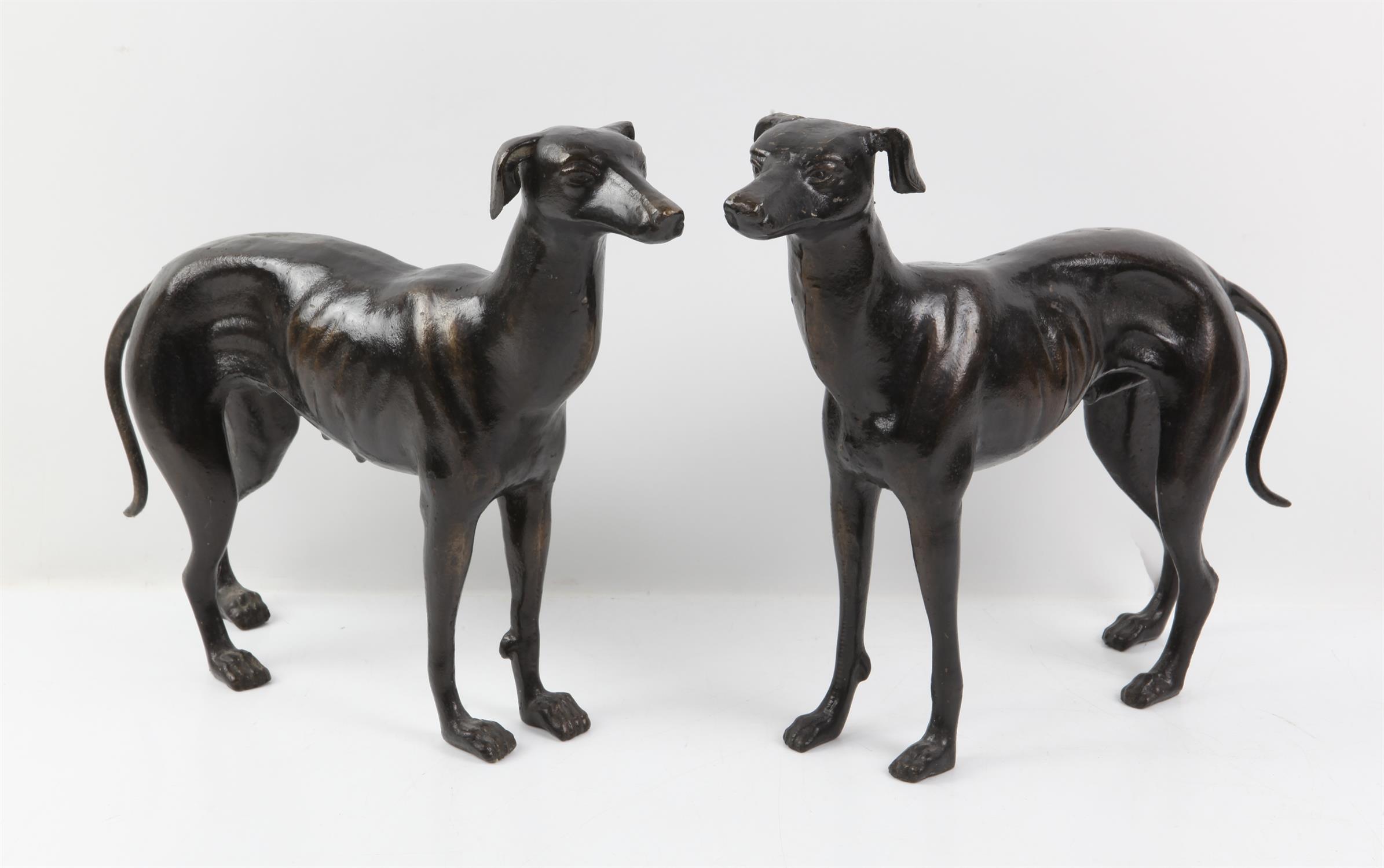 Pair of bronzed metal figures of a male and female greyhound, each approx. 29cm high x 38cm long