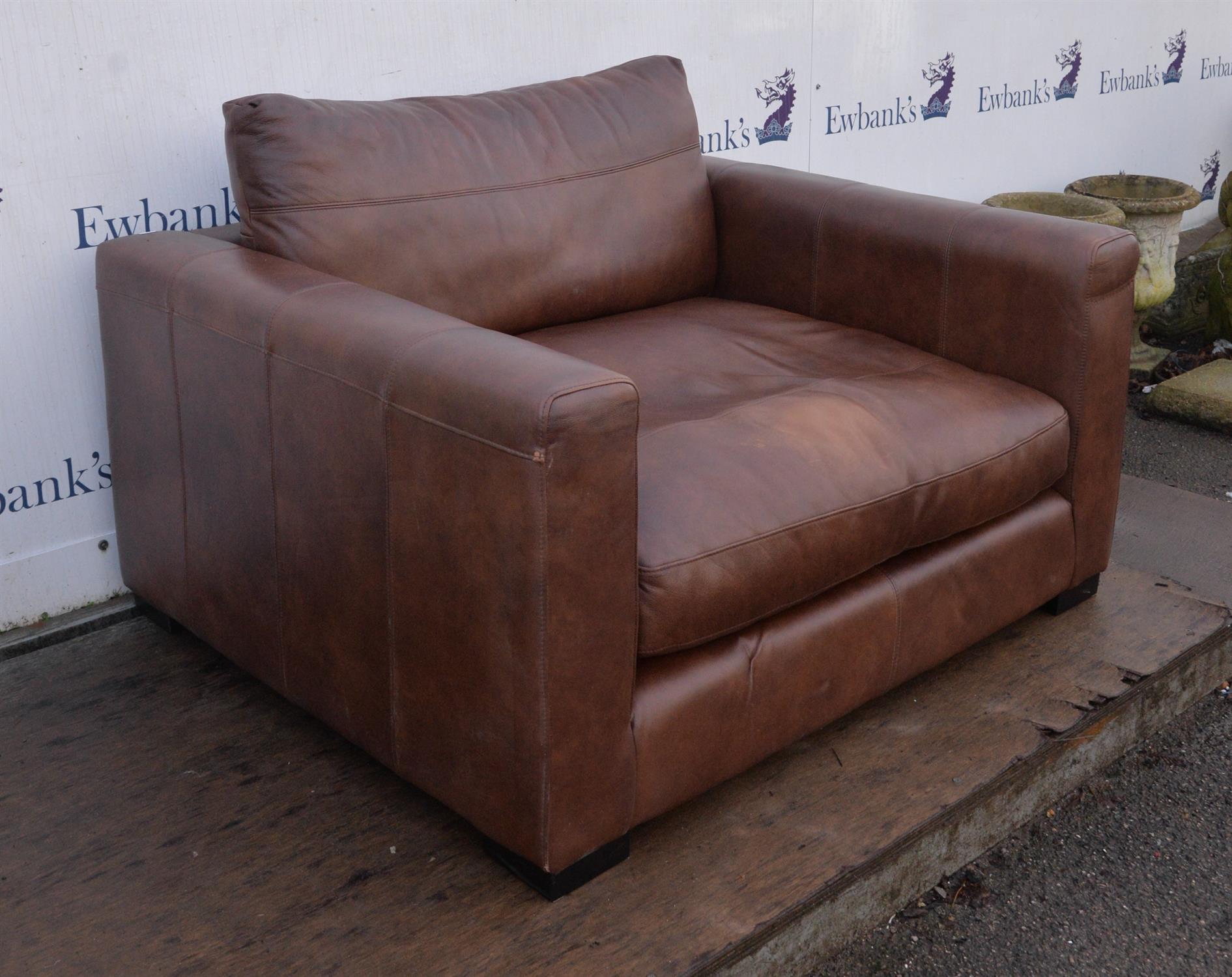 A large brown leather upholstered armchair raised on pad feet. 126 cm wide x 120 cm deep x 66 cm - Image 2 of 2