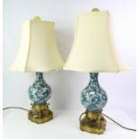 Pair of Chinese enamel and gilt metal lamps, early 20th Century, the bodies of vase form with white