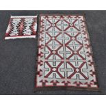 A Native American woven rug, decorated with geometric designs, in red, cream and brown hues,