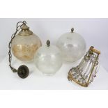 Three etched glass light shades of graduated sizes, with pineapple brass finials, tallest 31cm high,