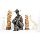 A Faux bronze Resin figure of a seated nude female wearing a hat, two sandalwood carved Indo