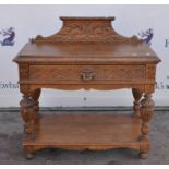A carved oak hall table with gallery back over single drawer raised on carved baluster supports.