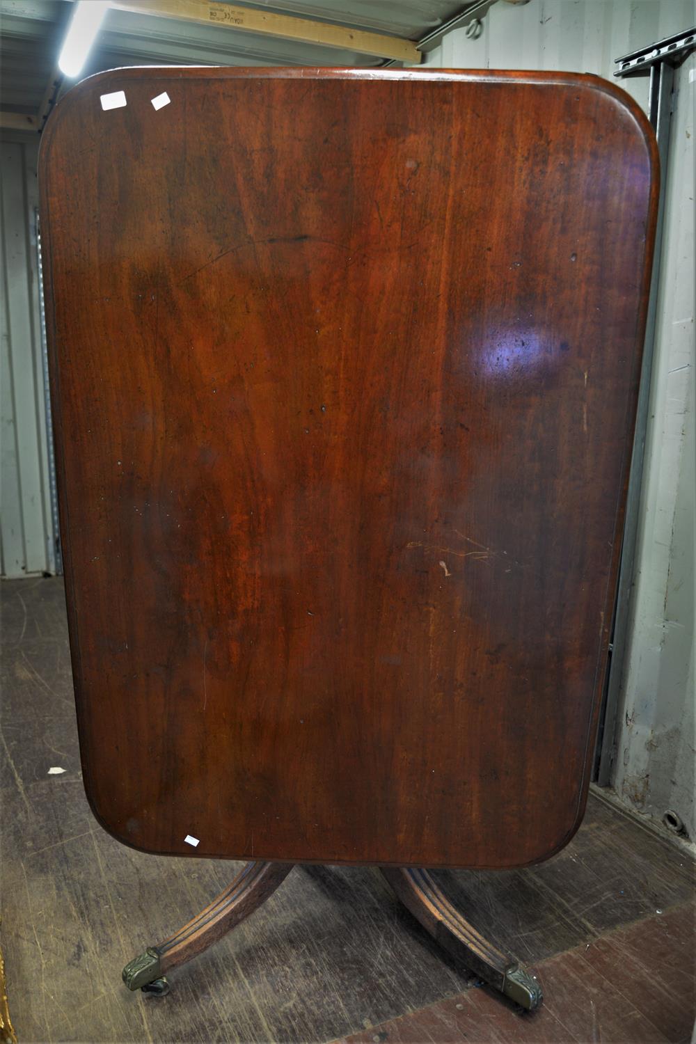 A 19TH Century mahogany dining table raised on quatrefoil base terminating on casters.