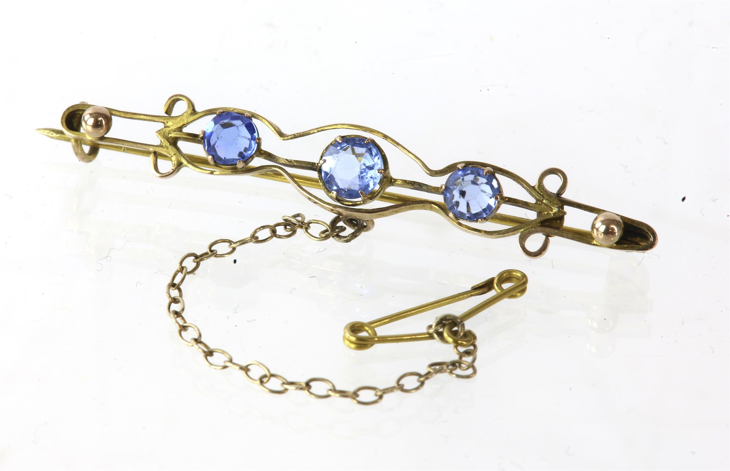 Three stone paste brooch, with three blue paste stones, tested as 9ct. with safety chain,