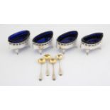 Set of four George III navette shaped open salts with pierced borders and blue glass liners,