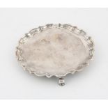 George II card tray with pie crust border on three hoof feet, the centre with clenched fist and