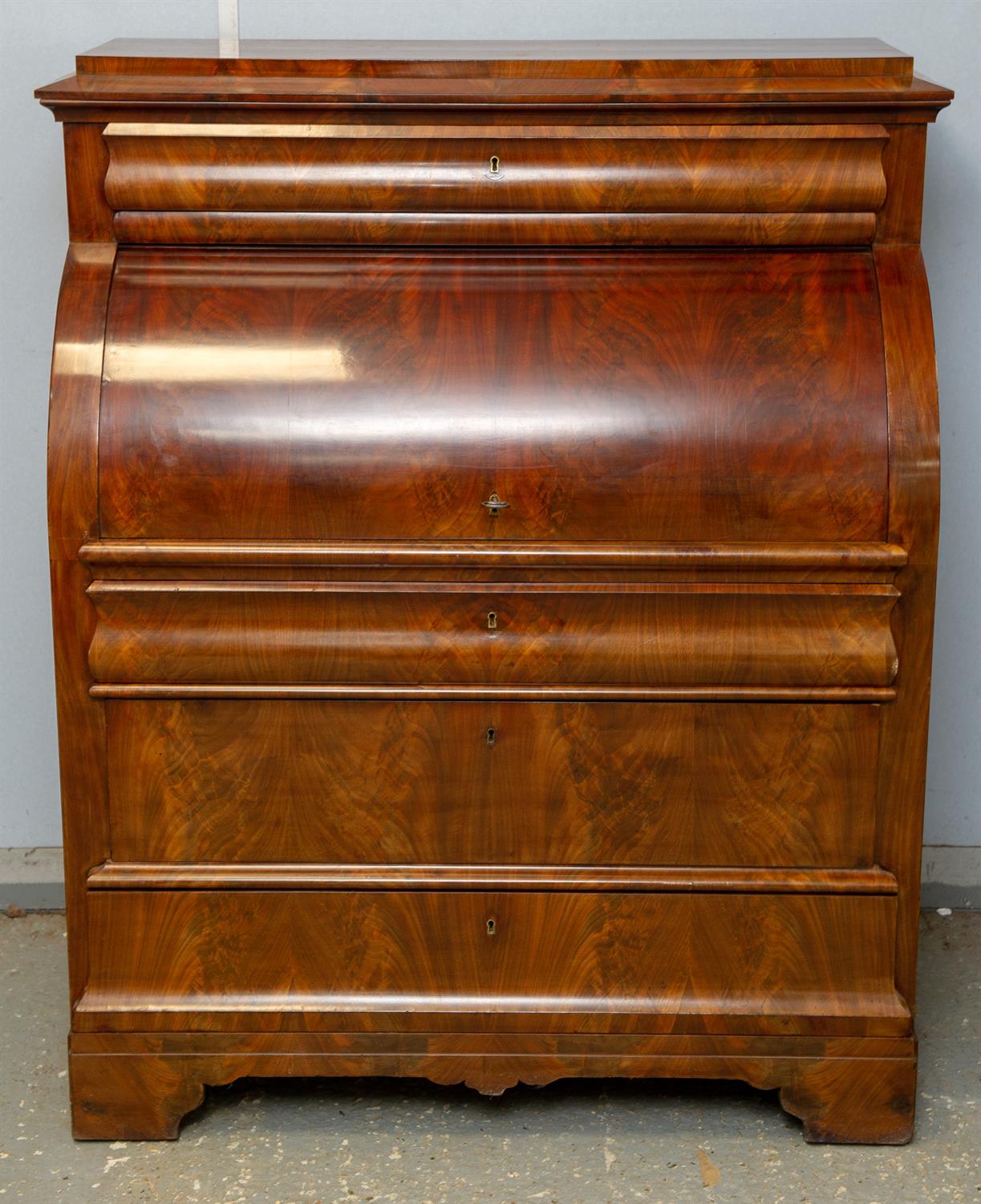 Continental flame mahogany veneered roll top bureau, 19th Century, with a frieze drawer over roll