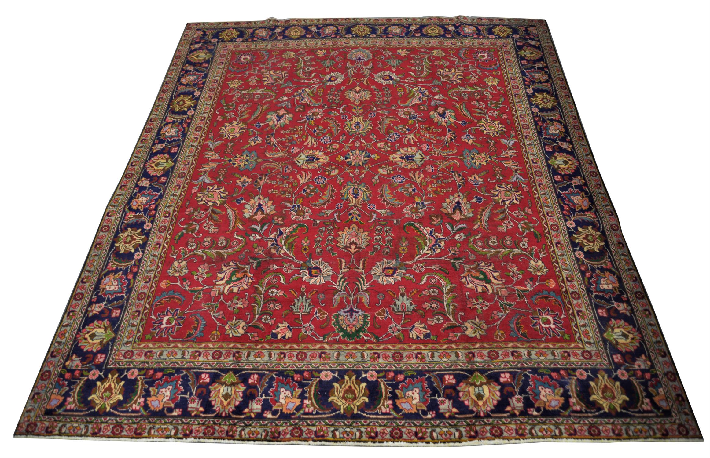 A Vintage red ground Persian Tabriz rug foliate field with blue borders.