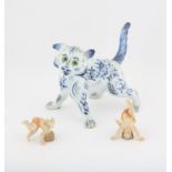 Modern delft pottery cat, in the Galle style, painted with flowers and with green glass eyes,