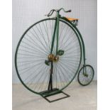 A penny-farthing / ordinary bicycle, with green painted steel frame, applied with shield to