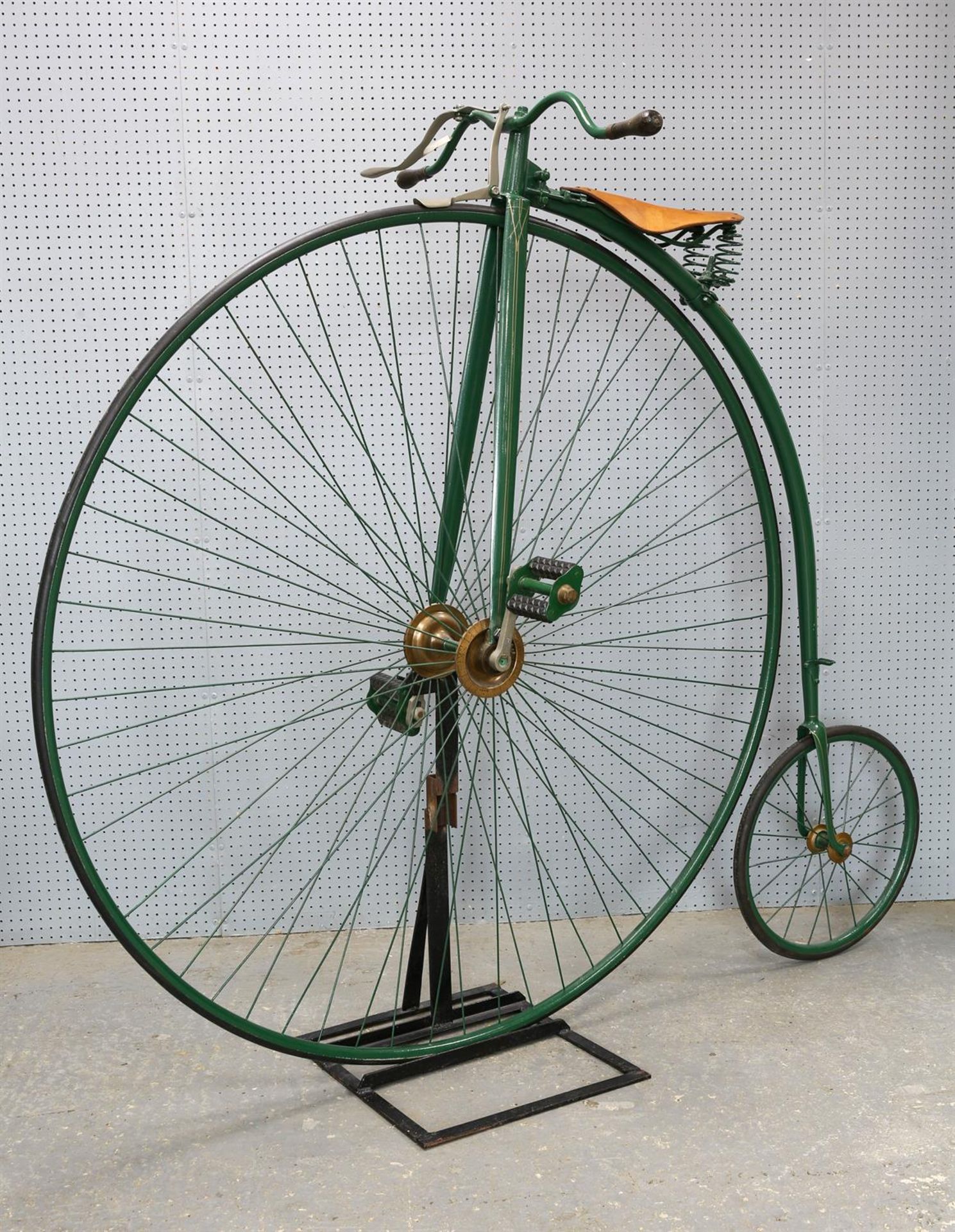 A penny-farthing / ordinary bicycle, with green painted steel frame, applied with shield to