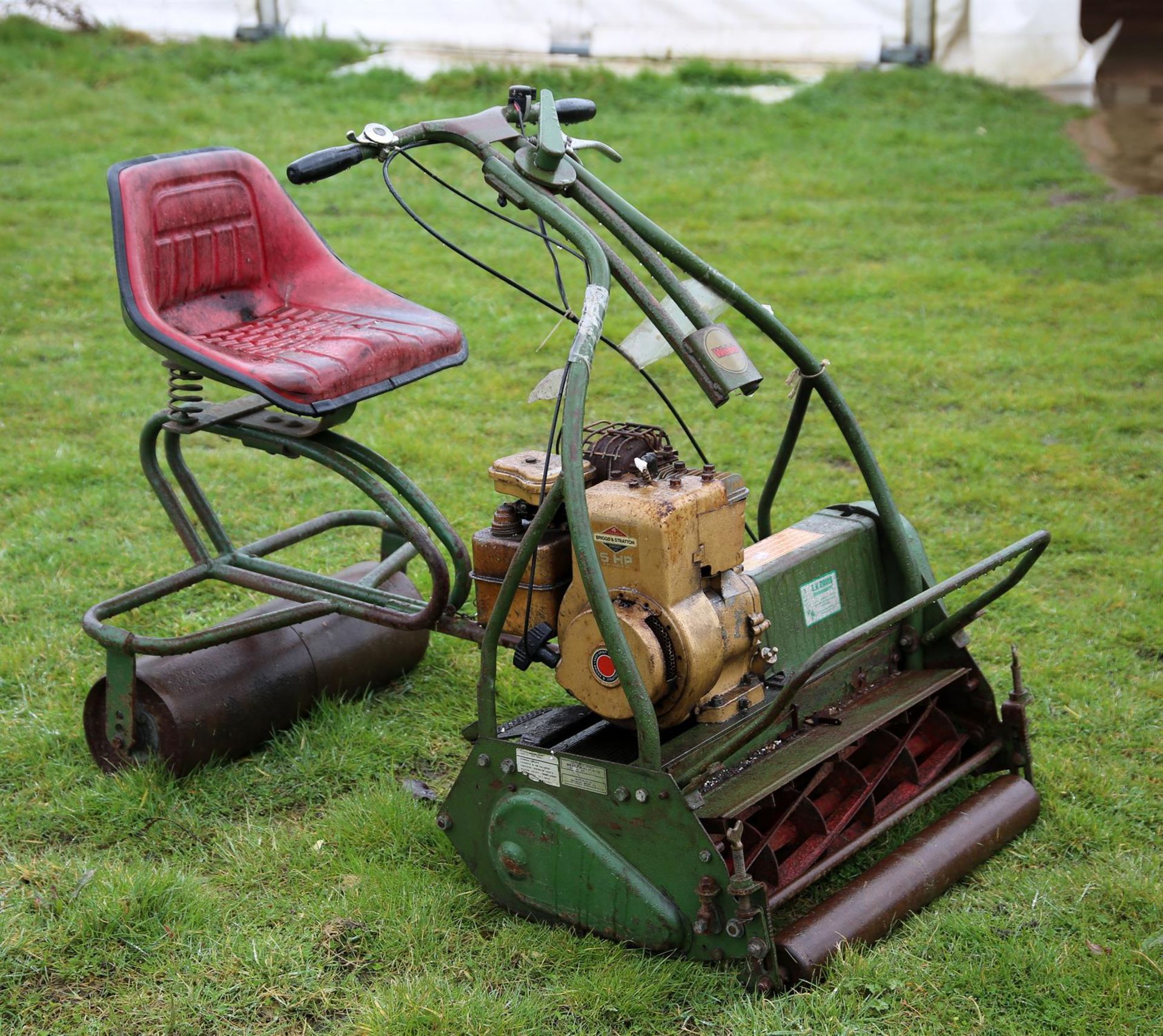 A Webb cylinder mower, green painted. With ride-on seat, the mower 100cm high x 73cm wide x 75cm