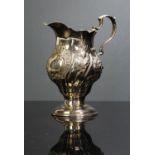 London 1767 silver cream or milk jug with embossed floral decoration.