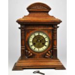 An Oak cased mantle clock with Roman numerals to chapter ring.