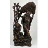 Chinese hardwood figure group of an Immortal holding a bat, 20th Century, with an attendant,