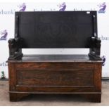 An oak monks bench, 20th Century, with hinged carved top, above carved arms decorated with lions,