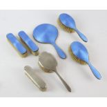 Engine turned blue enamel dressing table set comprising, hand mirror, two hair brushes and two