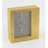 Jaeger LeCoultre Electric mantle clock, asymmetrical brushed gilt metal case, silvered rectangular