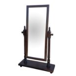 A mahogany cheval mirror, 20th Century, with a rectangular plate supported by two turned columns,