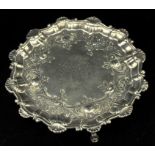 George III silver card tray embossed with foliate scrolls and a shell and scroll border,