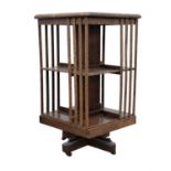 Oak revolving bookcase, early 20th Century, with two tiers, on stand with brass casters,