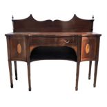 An Edwardian mahogany and inlaid serpentine fronted sideboard, with gothic arched back with urn