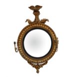 William IV giltwood and gesso convex mirror, with a spread eagle cresting above scrolling leaves,
