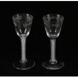 A pair of Georgian drinking glasses, each with bell form bowl engraved with grape and vine