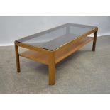 MANNER OF G PLAN, a teak coffee table, with smoked glass top, on a teak base with shelf,