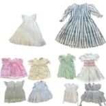A collection of 14 baby girl and children's dresses, mostly party dresses, ranging from the