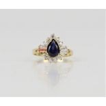 Synthetic sapphire and cubic zirconia dress ring, central pear cut sapphire weighing an estimated 1.