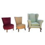 A wingback upholstered armchair, 20th Century, together with two upholstered low chairs (3).