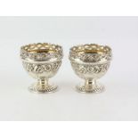 Ornate pair of silver egg cups with floral embossed body and pierced with Jackson and Fullerton,