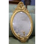 Victorian giltwood girandole mirror, the oval bevelled plate within a beaded ribbon frame with