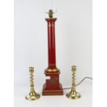 Red toleware lamp, 20th century, 61cm high, together with a pair of brass candlesticks (3)