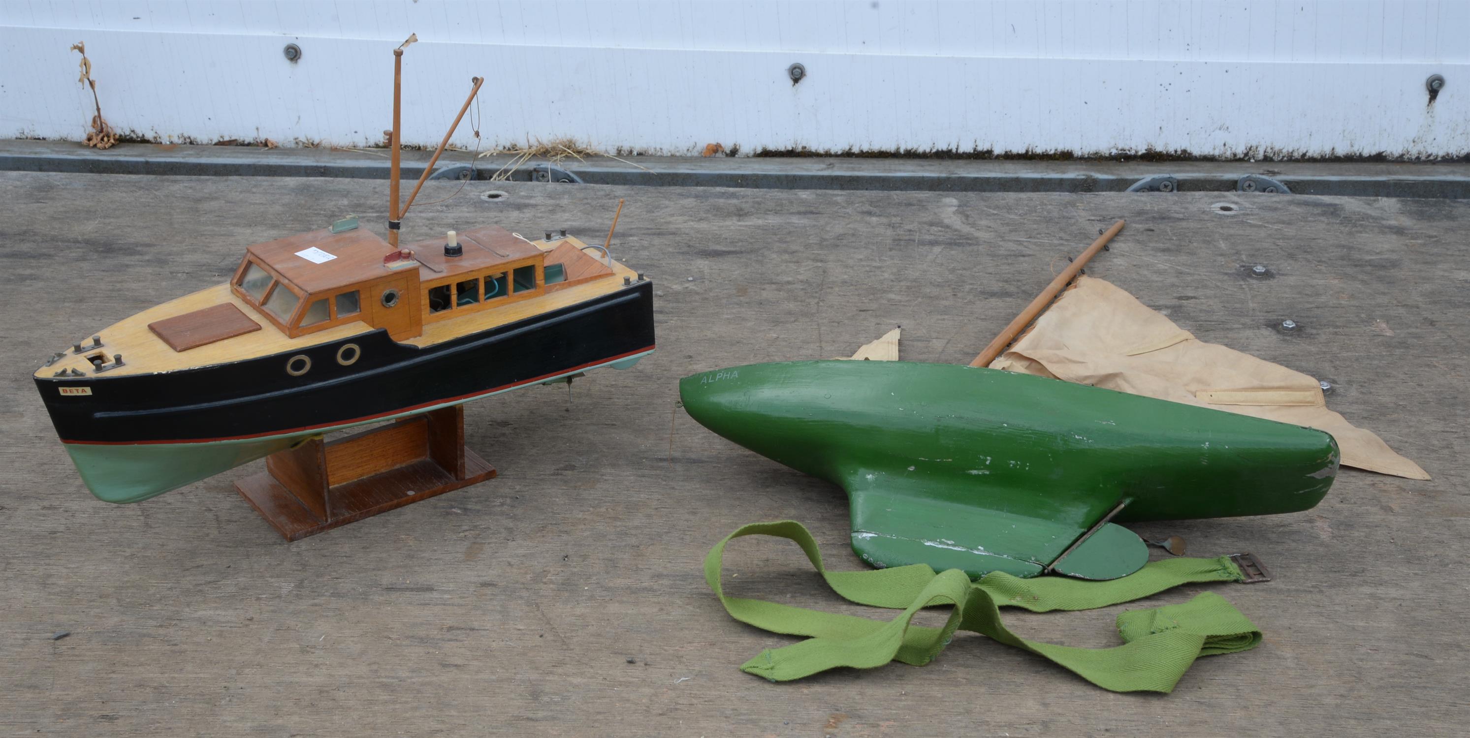 A plywood model of a boat, Beta, with cabin and electric motor, on stand, 43.5cm long,