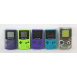 An assortment of 5 Gameboy Consoles Includes: Gameboy Colour (x4) and Gameboy - Clear (x1)